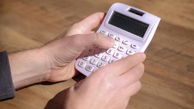 person at a desk using a calculator